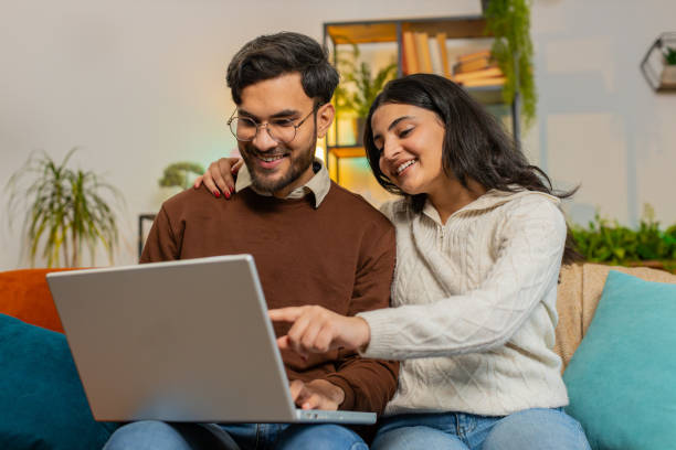 A young Indian couple planning finances at home using a laptop, smiling confidently – Vizzve Finance smart borrowing concept